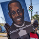 Brunswick, Georgia USA - January 18, 2021: Marcus Arbery, Sr., father of Ahmaud Arbery, carries a portrait of his son in the Rev. Martin Luther King, Jr. Day Parade.